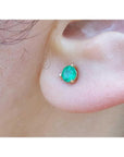 A cocktail emerald stud earring made of 14k yellow gold three prong set.
