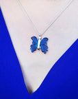 Dark blue natural agate butterfly pendant necklace with sterling silver chain on a woman's chest.