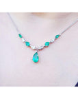 Pear shaped Emerald necklaces natural diamonds in 14k white gold with a wheat style chain on a woman's neck