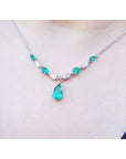 Pear shaped Emerald necklaces natural diamonds in 14k white gold with a wheat style chain on a woman's neck