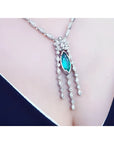 Marquise cut Colombian emerald necklace in 14K white gold with diamond links on a woman's chest.
