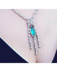 Marquise cut Colombian emerald necklace in 14K white gold with diamond links on a woman's chest.