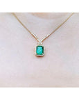 3.43 ct emerald halo necklace with natural diamonds on a 14K yellow gold chain.