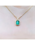 3.43 ct emerald halo necklace with natural diamonds on a 14K yellow gold chain.