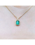 3.43 ct emerald halo necklace with natural diamonds on a 14K yellow gold chain.