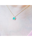 Emerald-cut emerald necklace east west orientation encircled in a halo of natural diamonds