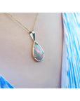 Pear-shaped Ethiopian Welo opal pendant with fire red-orange play of color, set in 14K yellow gold.