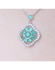 14K white gold cluster necklace with natural Colombian emeralds and diamond 4-leaf clover silhouette.