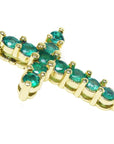 A 14k yellow gold cross necklace pendant with natural colombian emeralds on a side profile view.