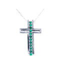 A white gold cross pendant with colombian emeralds on a topside view position.
