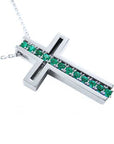 A cross-shaped pendant necklace with round cut emeralds prong set in 14K white gold.
