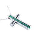 A cross-shaped pendant necklace with round cut emeralds prong set in 14K white gold.