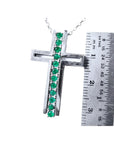 14K white gold cross pendant with 0.50 ct. round Colombian emeralds, shown with a ruler for size.
