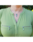 0.50 ct. Colombian emerald cross pendant necklace with round cut emeralds, 14K gold, worn on a woman.