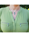0.50 ct. Colombian emerald cross pendant necklace with round cut emeralds, 14K gold, worn on a woman.