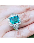 GIA certified 3.98 ct. emerald and diamond ring in 18K white gold, featuring a halo and trillion cut sides.