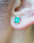 Close-up of an ear wearing a natural emerald stud earring.