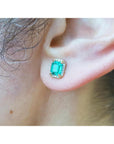 Close-up of an ear wearing a natural emerald stud earring.