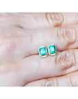 Rectangular Colombian emerald and diamond halo stud earrings in 14k yellow gold.