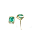 Pair of emerald green gemstone earrings with gold settings on a white background.