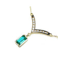14K yellow gold necklace with a baguette-cut Colombian emerald and diamond-studded curved V pendant.