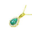 Pear-shaped Colombian emerald pendant with halo diamonds on a 14K yellow gold chain.