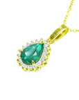 Gold pendant with a natural teardrop colombian emerald and diamond accents on a left side profile view.