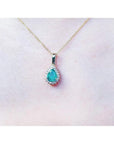 Pear-shaped Colombian emerald pendant with halo diamonds on a 14K yellow gold chain.