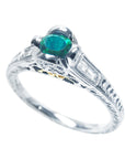 This natural oval cut colombian emerald ring displays its partial top and side angle.