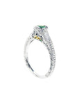 Oval-cut Colombian emerald ring in 14K white gold with baguette diamond accents and intricate filigree.