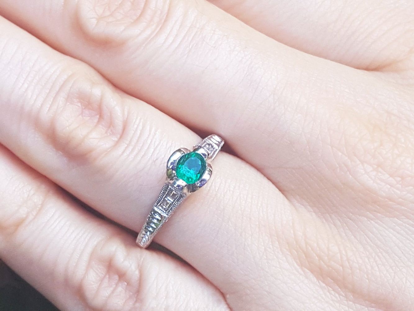 A natural oval cut colombian emerald ring in white gold a hand.