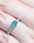 A natural oval cut colombian emerald ring in white gold a hand.