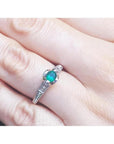 Oval-cut Colombian emerald ring with baguette diamonds in 14K white gold on a hand.