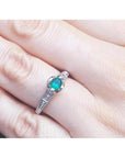 Oval-cut Colombian emerald ring with baguette diamonds in 14K white gold on a hand.