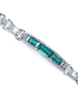White gold bracelet with three rectangular Colombian emeralds surrounded by princess cut diamonds.