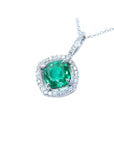 Cushion-cut Colombian emerald pendant with diamond halo in 14K white gold.