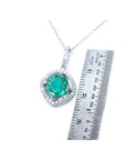 Emerald pendant on a white gold chain with a ruler for scale on a white background.