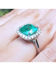 3.69 ct cushion cut Colombian emerald engagement ring with diamond halo in 18K white gold.