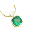 Gold necklace with a natural colombian emerald pendant on a white background