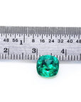 1.62 carat GIA certified emerald, cushion cut, vibrant medium-deep bluish-green, shown with ruler for scale.