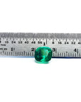2.06 carat cushion cut Muzo Colombian emerald, sparkling medium-deep bluish green, shown with a ruler.
