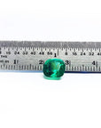 2.06 carat cushion cut Muzo Colombian emerald, sparkling medium-deep bluish green, shown with a ruler.
