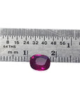Vibrant red 1.18 carat cushion-cut natural ruby gemstone next to a ruler for scale.