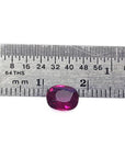 Vibrant red 1.18 carat cushion-cut natural ruby gemstone next to a ruler for scale.