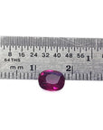 Vibrant red 1.18 carat cushion-cut natural ruby gemstone next to a ruler for scale.
