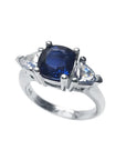 14K white gold ring with a deep blue cushion-cut sapphire and two trillion-cut white sapphires.