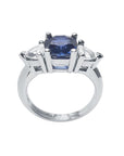 14K white gold cushion cut deep blue sapphire ring with two trillion side sapphires.