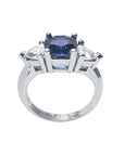 14K white gold cushion cut deep blue sapphire ring with two trillion side sapphires.