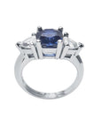 14K white gold cushion cut deep blue sapphire ring with two trillion side sapphires.