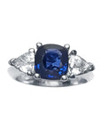 Women's cushion cut natural sapphire ring with trillion side white sapphires made of 14k white gold.